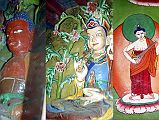 107 Marpha Gompa - Amitabha And Padmasambhava Statues, Guitar Playing Buddha Painting There were three statues behind the glass at the Marpha Gompa: on the left Avalokiteshvara (not shown), in the centre red Amitabha, on the right Padmasambhava. There are many paintings on the wall, including a guitar playing Buddha.